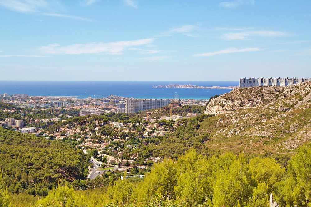 Vue panoramique d'une ville côtière entre collines et mer sous ciel bleu Vue panoramique d'une ville côtière entre collines et mer sous ciel bleu