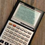 Calculatrice scientifique Casio affichant plusieurs résultats numériques sur bois
