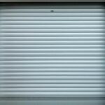 Porte à enroulement métallique fermée, lignes horizontales régulières, cadre gris