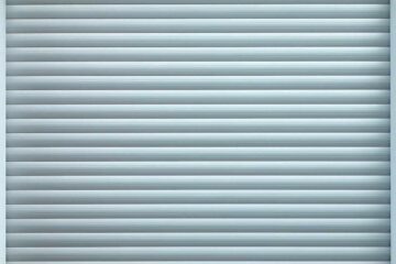 Porte à enroulement métallique fermée, lignes horizontales régulières, cadre gris