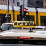 Un taxi jaune avec enseigne sur le toit, vue arrière d'une voiture