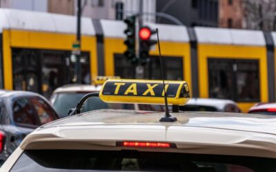 Un taxi jaune avec enseigne sur le toit, vue arrière d'une voiture